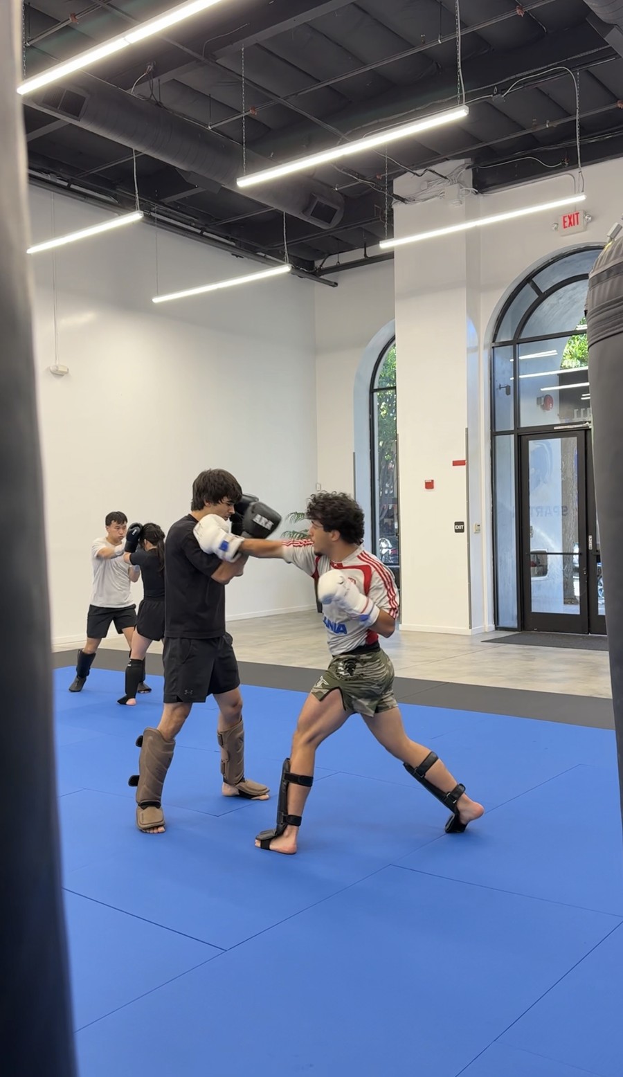 Students sparring on the bags